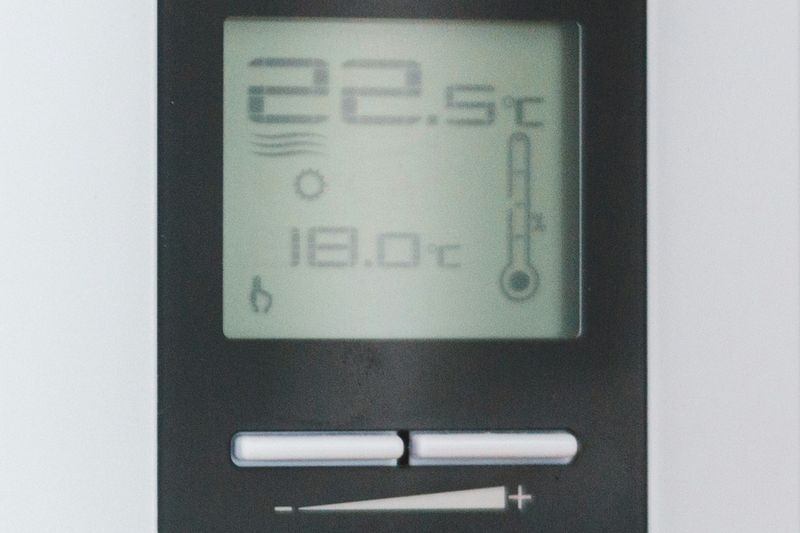 Digital wall thermostat displaying 22.5 degrees Celsius.